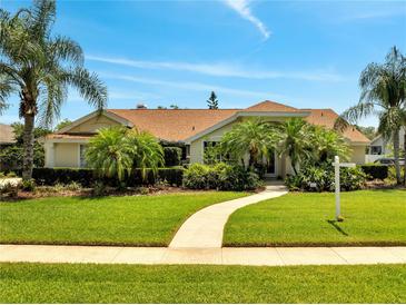 Beautiful home with lush landscaping, green lawn, and a winding walkway leading to the front door at 1121 Arbor Glen Cir, Winter Springs, FL 32708