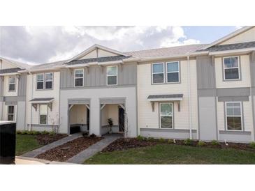 Charming townhome with inviting entryway and manicured landscaping on a sunny day at 1264 Blue Island Dr, Clermont, FL 34714