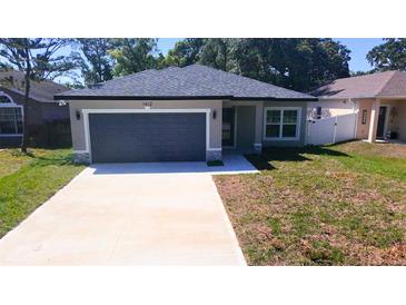 Charming single-story home featuring a gray exterior, a two-car garage, and a well-maintained front yard at 1412 Pine St, Orlando, FL 32824