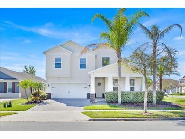 Charming two-story home with a well-manicured lawn and lovely palm trees at 14518 Black Quill Dr, Winter Garden, FL 34787