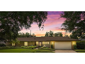 Charming ranch-style home with well-manicured lawn and mature trees in a tranquil setting at dusk at 1618 Pepperidge Dr, Orlando, FL 32806