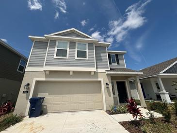 Two-story home showcasing a neutral color palette, an attached two-car garage, and well-maintained landscaping at 264 Hayley St, Winter Haven, FL 33884