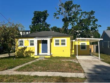 Charming yellow home with a blue front door and covered carport offers curb appeal at 5216 Davisson Ave, Orlando, FL 32810