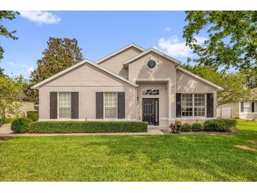 Charming single-story home with manicured lawn, dark shutters, and neutral stucco exterior at 530 Hiawatha Palm Pl, Apopka, FL 32712
