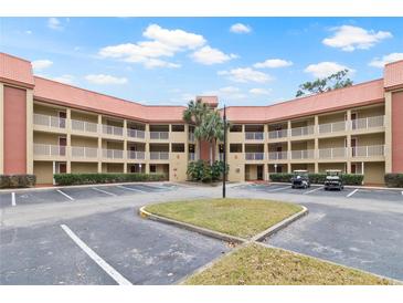 Beautiful building complex with a terra cotta tile roof, white railings, and manicured landscaping at 6402 Parc Corniche Dr # 5304, Orlando, FL 32821