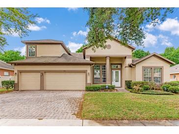 Charming two-story home with a three-car garage, well-manicured lawn, and beautiful landscaping at 902 Hire Cir, Ocoee, FL 34761