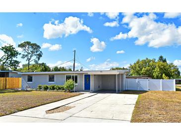 Charming single-story home featuring a well-manicured lawn, blue door, and a convenient carport at 994 Lormann Cir, Longwood, FL 32750
