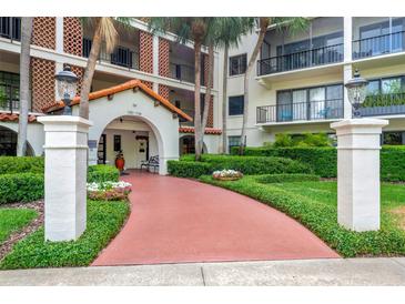 Inviting building entrance with a terracotta walkway, lush landscaping, and classic architectural details at 100 S Interlachen Ave # 410F, Winter Park, FL 32789
