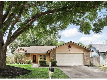 Charming single-story home with a well-manicured lawn, mature trees, and a two-car garage at 10049 Custer Cir, Orlando, FL 32817