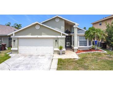 Charming single Gathering home featuring an attached garage, manicured lawn, and inviting curb appeal at 1021 Whalebone Bay Dr, Kissimmee, FL 34741