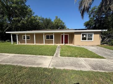 Charming single-story home featuring a covered porch and well-maintained lawn at 1108 Bear Lake Rd, Apopka, FL 32703