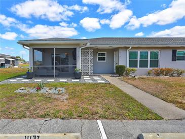 Charming single-story home with a screened porch, well-manicured lawn, and inviting walkway at 11137 Acme Dr # 207A, Orlando, FL 32825