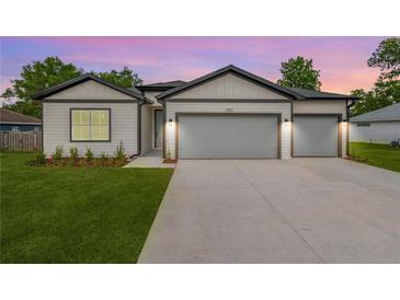 Charming home featuring a two-car garage, inviting facade, and manicured lawn at 13312 Sw 41St Ct, Ocala, FL 34473