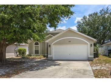 Charming one-story home featuring an attached two car garage and mature landscaping at 135 Andrews Rd, Sanford, FL 32773