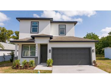 Beautiful two-story home with a dark gray garage door and a well-manicured lawn with blue sky in the background at 2041 Warrens Ave, Maitland, FL 32751