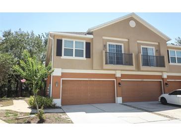 Townhouse with brown garage doors, beige siding, and small balconies at 2530 San Jacinto Cir # 2530, Sanford, FL 32771