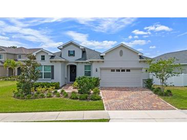 Charming single-Gathering home showcasing a brick driveway, meticulously maintained landscaping, and an attached two-car garage at 4296 Mirror Ct, Clermont, FL 34714