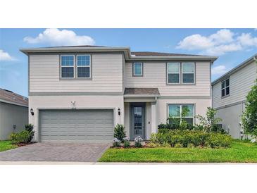 Charming two-story home with a manicured lawn, beautiful landscaping and gray siding at 4336 Foggy Oak Ln, Sanford, FL 32773