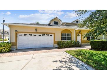 Inviting home with a two-car garage, well-maintained lawn, and a welcoming entrance at 13241 Fountainbleau Dr, Clermont, FL 34711