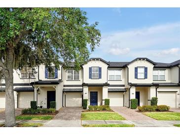 Charming townhomes featuring blue shutters, brick driveway, and well-maintained landscaping at 10374 Park Commons Dr, Orlando, FL 32832