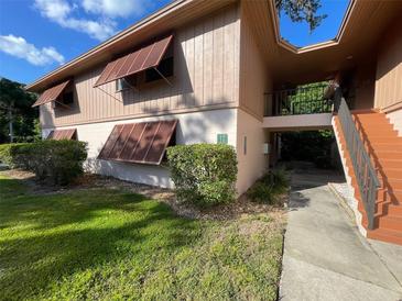 Two-story condo building with well-maintained landscaping and shutters on the windows at 170 Palmetto Woods Ct # 1A, Deltona, FL 32725