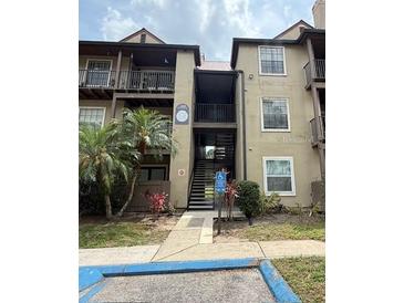 Condominium building featuring stairs leading to upper units, tropical landscaping, and accessible entrance at 208 Afton Sq # 307, Altamonte Springs, FL 32714