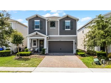 Charming two-story home features a two-car garage, brick paver driveway, and inviting covered porch at 2264 Emerald Springs Dr, Apopka, FL 32712