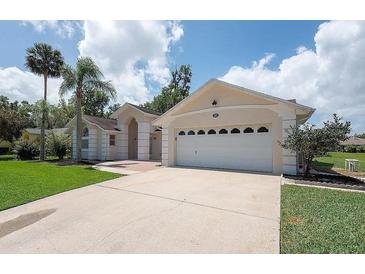 Charming single-story home featuring a two-car garage, well-manicured lawn and mature palm trees, located in a serene neighborhood at 23 Old Sunbeam Dr, South Daytona, FL 32119