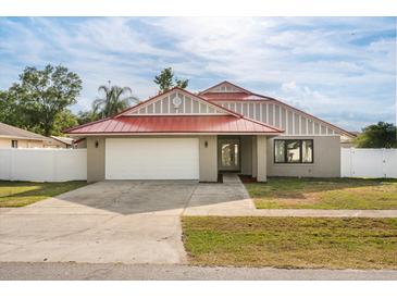 Charming home with a red roof, a two-car garage, and a well-maintained front yard at 2426 Abbey Ave, Orlando, FL 32833