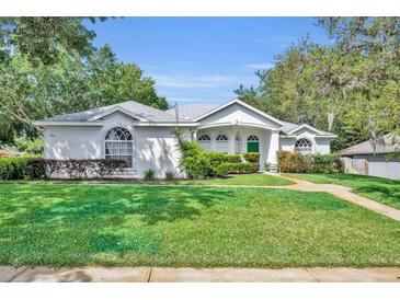 Well-manicured lawn and lush landscaping enhance this charming single-story home's curb appeal at 288 Englenook Dr, Debary, FL 32713