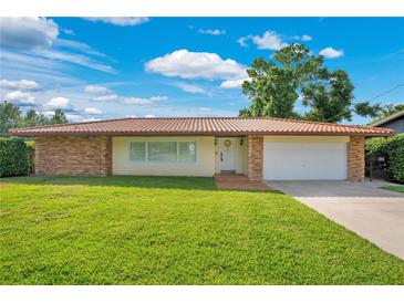 Charming single-story home with a well-maintained lawn, brick accents, and a neutral-colored exterior under a blue sky at 3108 Troy Dr, Orlando, FL 32806