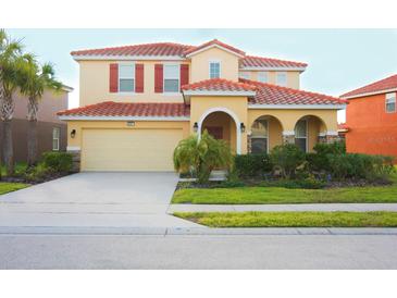 Charming two-story home featuring a red tile roof, neutral exterior, and a well-maintained front lawn at 4405 Acorn Ct, Davenport, FL 33837