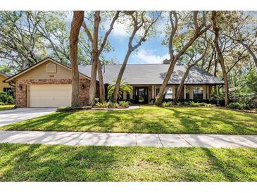 Charming brick home with mature trees, well-manicured lawn, and attached two car garage at 1039 Whispering Cv, Casselberry, FL 32707