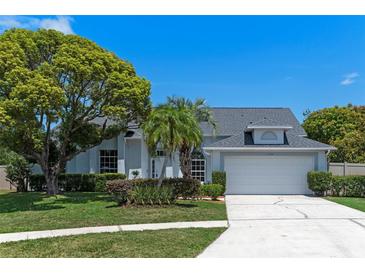 Charming single-Gathering home featuring mature landscaping, a two-car garage, and a well-maintained lawn at 11705 Binfield Ct, Orlando, FL 32837
