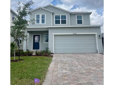 Charming two-story home features a brick driveway, two-car garage, and landscaped front yard at 1908 Diamond Head Cir, Lake Hamilton, FL 33851