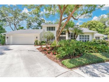 Charming two-story home featuring a well-manicured lawn, mature trees, and a large front yard with beautiful landscaping at 3332 Stonewood Ct, Orlando, FL 32806