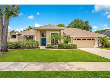 Charming single-story home features a well-manicured lawn, a blue front door, and attached two-car garage at 4119 Pecan Ln, Orlando, FL 32812