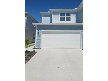 Light blue two-story home with a white garage door and concrete driveway at 4762 Sparkling Shell Ave, Kissimmee, FL 34746