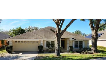 Charming single-story home with a well-maintained lawn and an attached two-car garage at 697 Winding Lake Dr, Clermont, FL 34711
