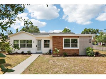 Charming single-story home boasting a mix of modern wood and white siding, manicured lawn, and inviting curb appeal at 730 W Swoope Ave, Winter Park, FL 32789