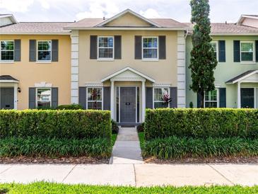 Charming townhouse with colorful facade, gray shutters, and manicured shrubbery at 110 S Primrose Dr, Orlando, FL 32803