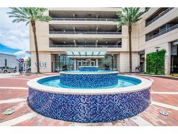 Beautiful blue tiled water fountain in front of The Vue at Lake Lola entrance with a covered drive through and palm trees at 150 E Robinson St # 2812, Orlando, FL 32801