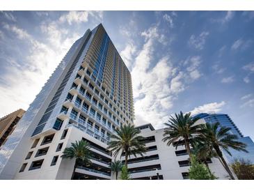 Contemporary condominium high rise featuring balconies and a parking garage set against a cloudy blue sky at 150 E Robinson St # 3408, Orlando, FL 32801