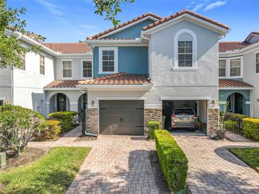 Charming townhome featuring a tile roof, attached garage, and landscaped front yard at 1772 Garden Sage Dr, Oviedo, FL 32765