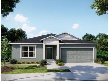New construction home with a neutral gray color, complemented by green lawn and manicured landscaping at 3238 Viceroy Ct, Poinciana, FL 34759