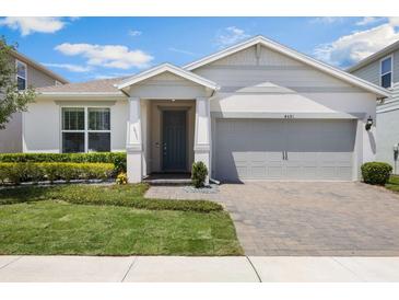 Charming single Gathering home featuring a manicured lawn and covered front entryway at 4591 Gliding Wave St, Winter Garden, FL 34787