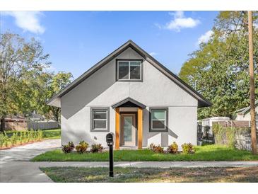 Charming home featuring a neutral paint, framed windows, and lush landscaping at 600 Lakewood Ave, Ocoee, FL 34761