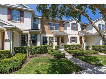 Charming two-story townhome with well-manicured lawn and shrubbery in a desirable community at 7010 Broomshedge Trl, Winter Garden, FL 34787