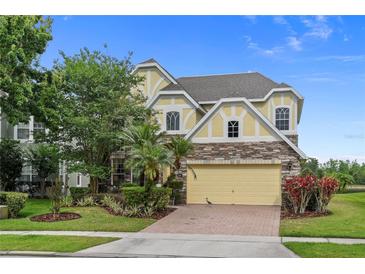 Charming two-story home featuring stone accents, a two-car garage, and a beautifully landscaped front yard at 850 Spring Oak Cir, Orlando, FL 32828