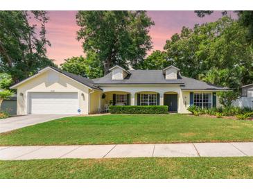 Charming single-story home with a manicured lawn, attached garage, and welcoming front porch at 1018 Featherstone Cir, Ocoee, FL 34761